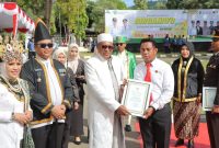 Wabup Kepsul Menyerahkan Piagam Penghargaan Kepada Kanit PPA Satreskrim Polres Sula, Bripka Ikbal Umanailo.